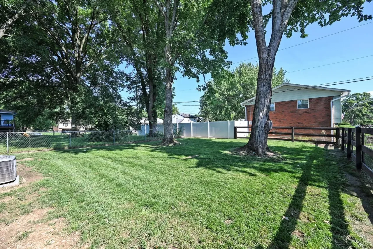 Fenced backyard with mature shade trees
