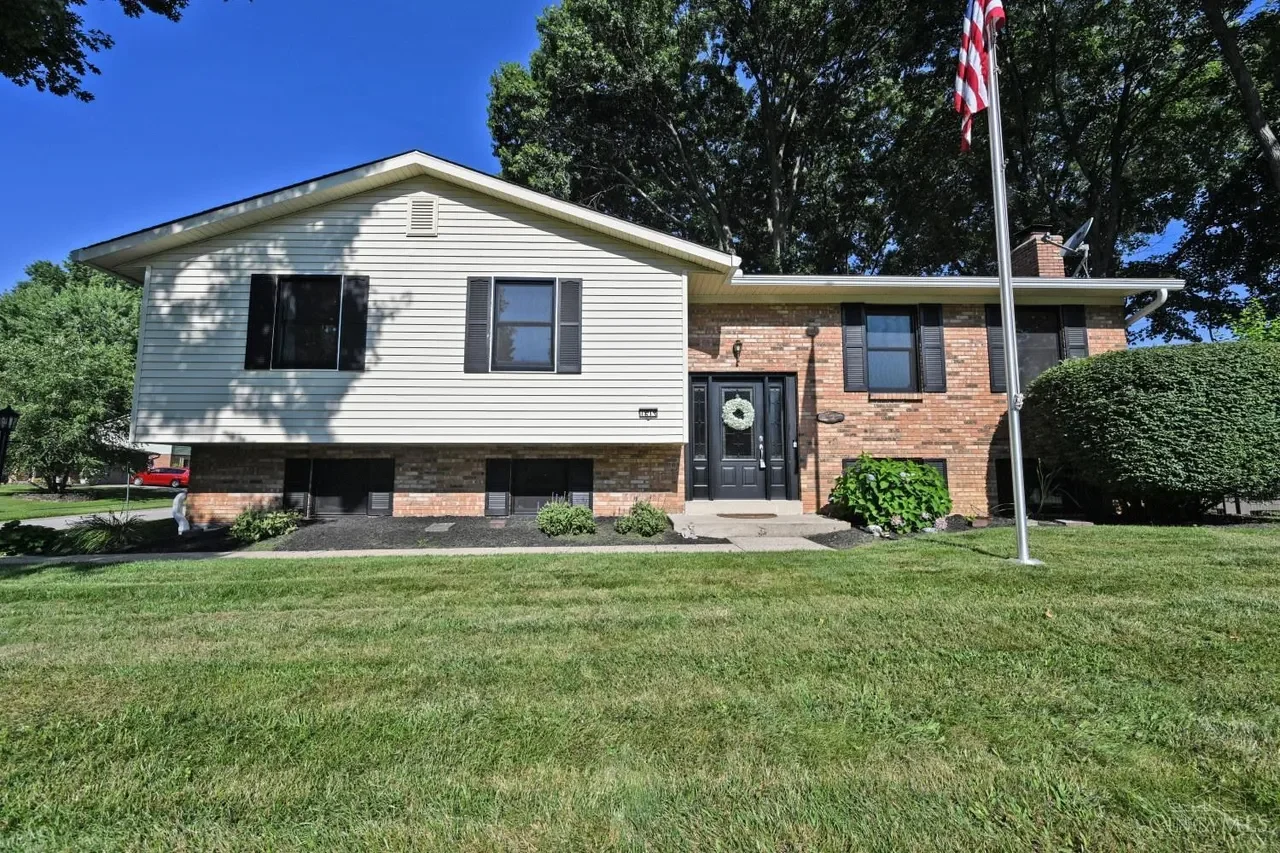 Front exterior of 1613 Muskegon Drive, with its lawn and mature trees